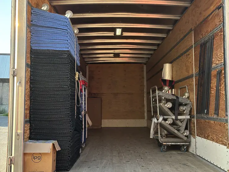 Long-distance truck loaded with a mattress and secured furniture, doors open