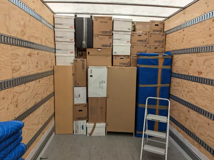 Boxes and a wardrobe carton loaded in a truck for a small move